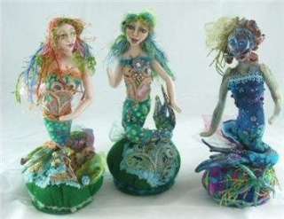   mermaids perched atop beaded and embellished pincushions great way